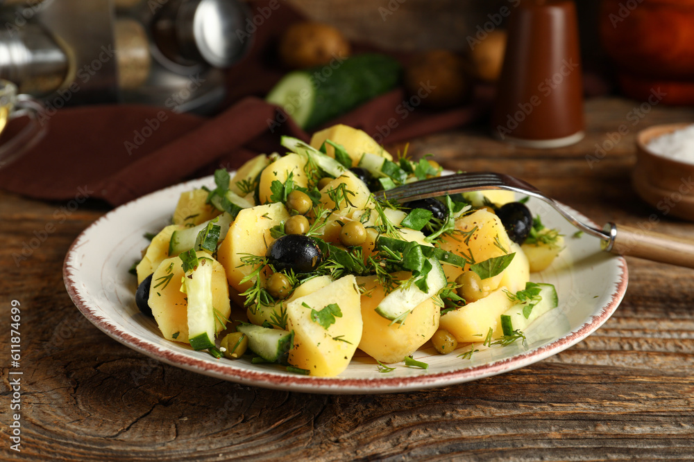 Plate of tasty Potato Salad with vegetables on wooden background