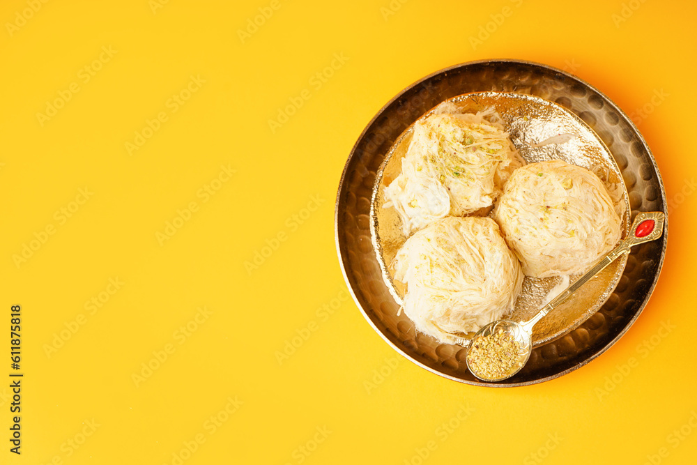 Plates with tasty Turkish Pismaniye on yellow background