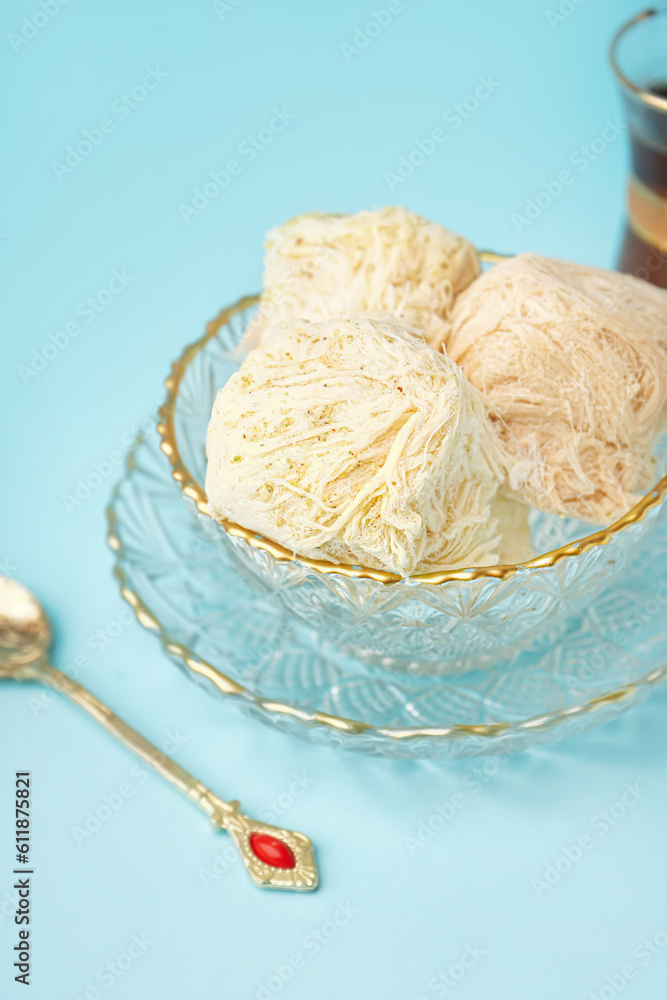 Bowls with tasty Turkish Pismaniye on blue background