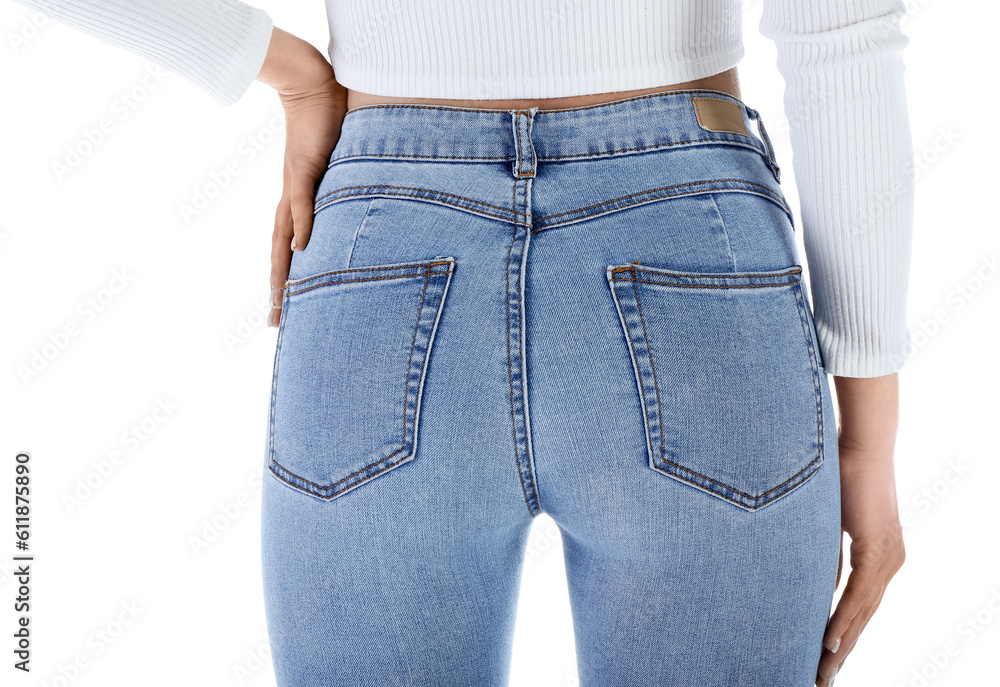 Young woman in skinny jeans on white background, back view