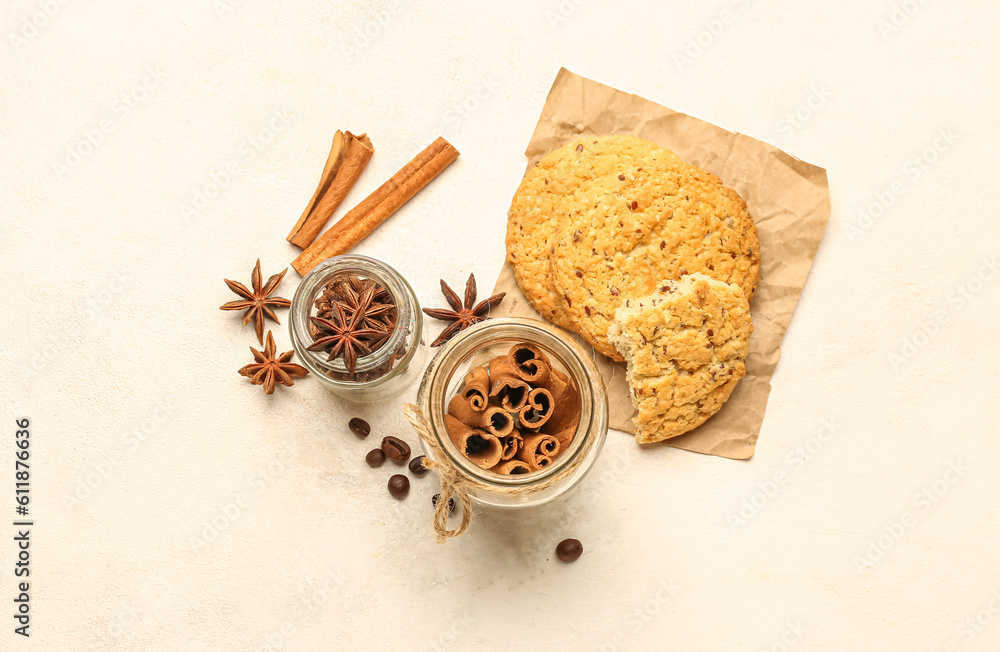 Composition with cinnamon sticks, anise stars and tasty cookies on light background