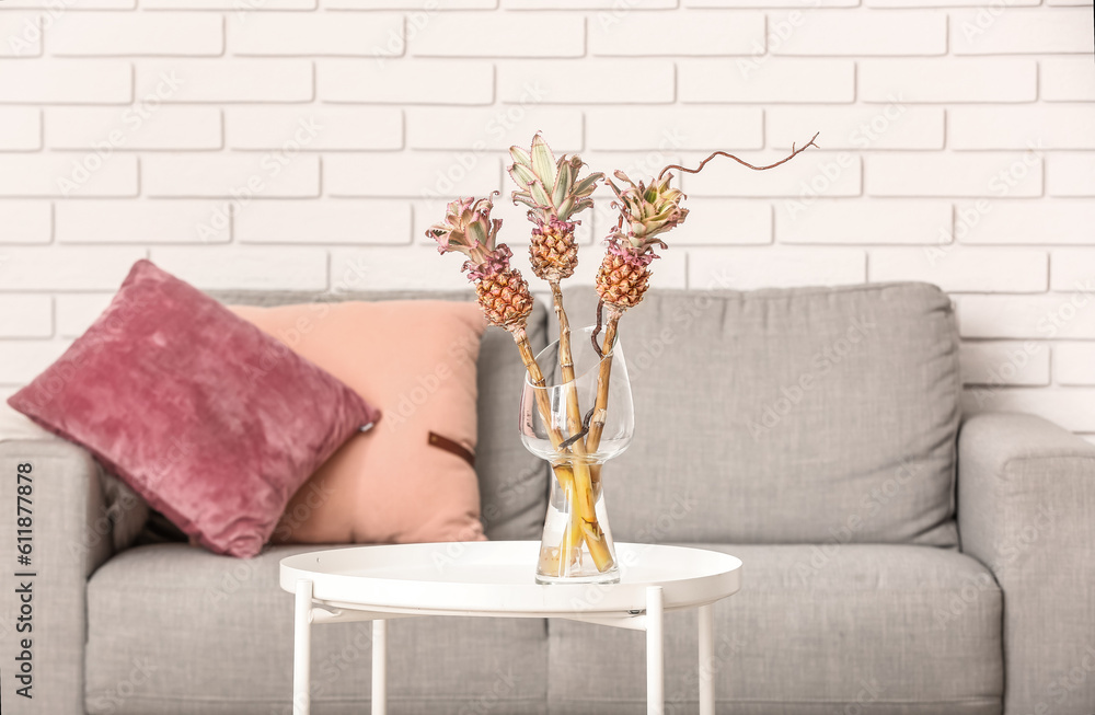 Vase with baby pineapples on table in living room