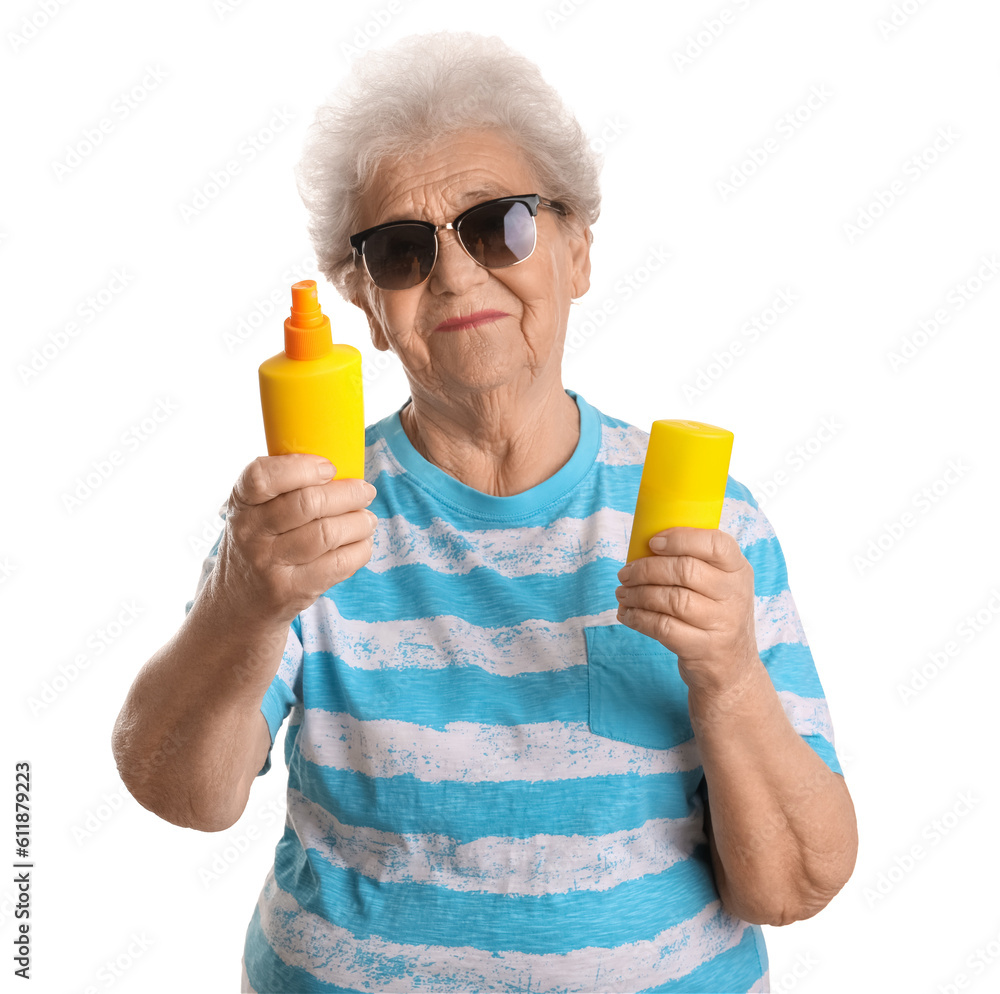 Senior woman with bottles of sunscreen cream on white background