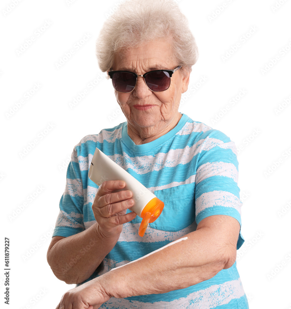 Senior woman applying sunscreen cream on white background