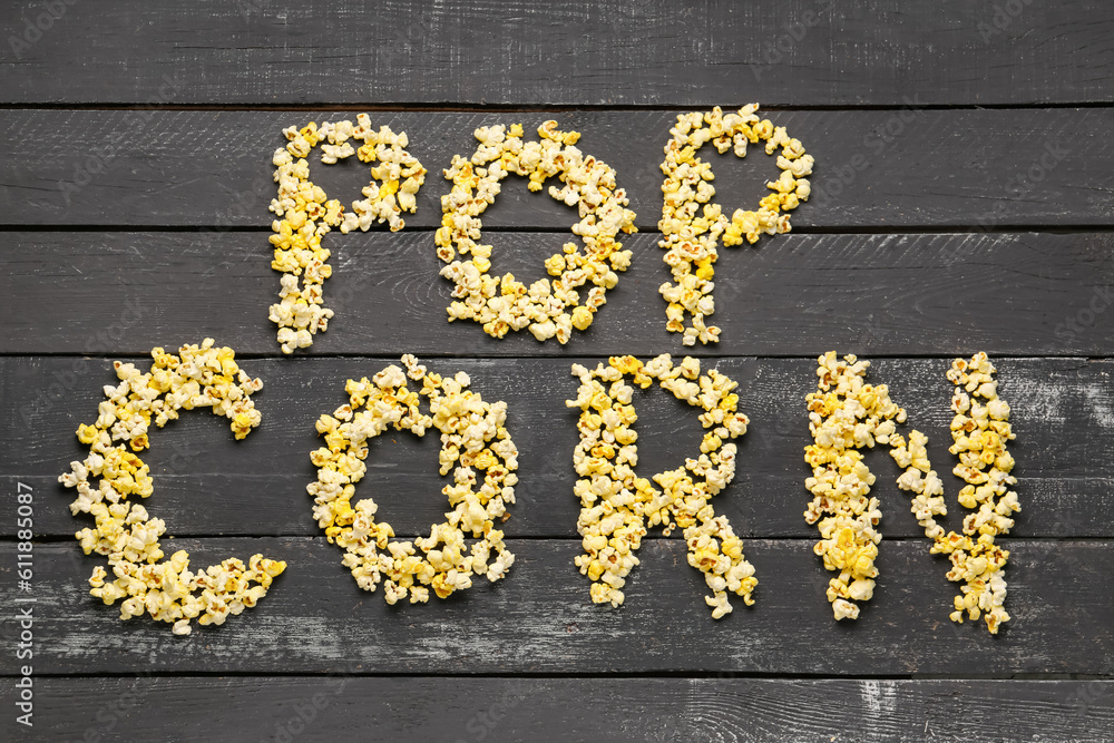 Text POP CORN on dark wooden background