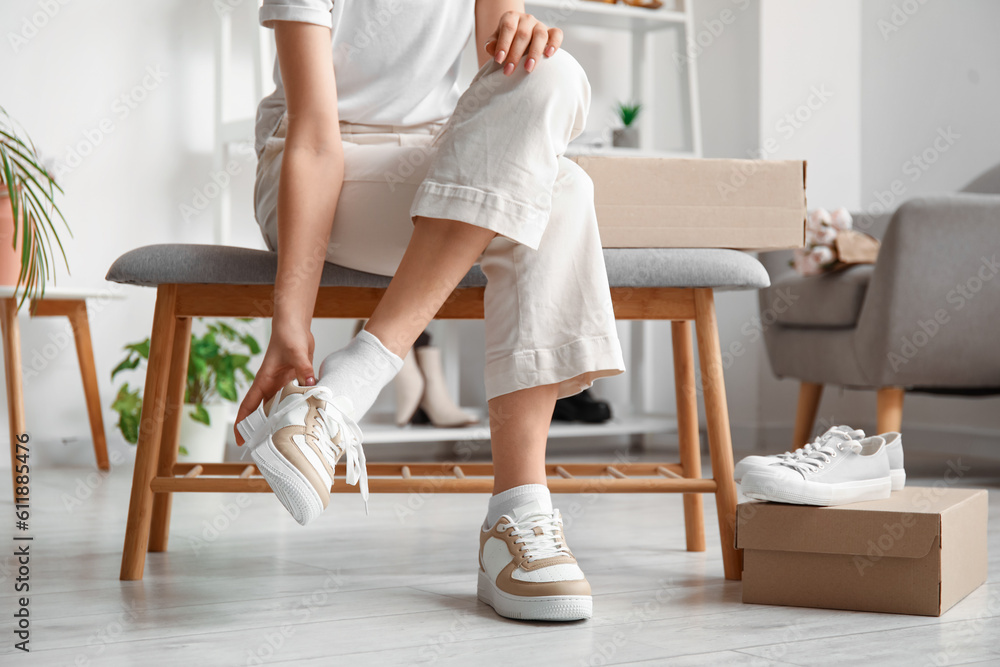 Woman trying on stylish sneakers in boutique