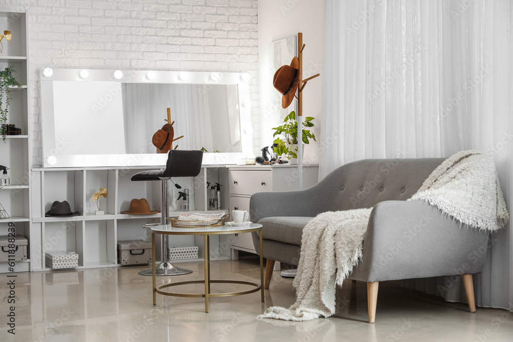 Interior of beauty salon with hairdresser table and comfortable sofa