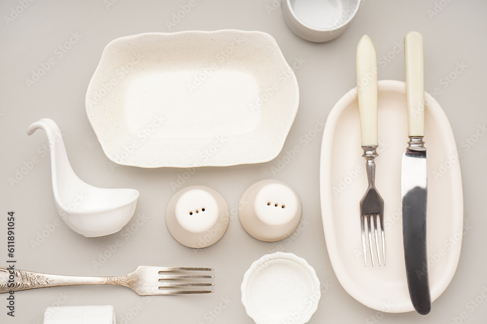 Set of stylish tableware on grey background