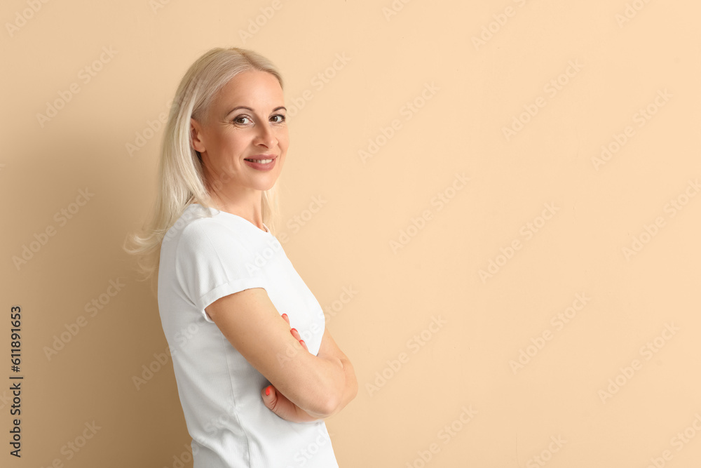 Mature blonde woman on beige background