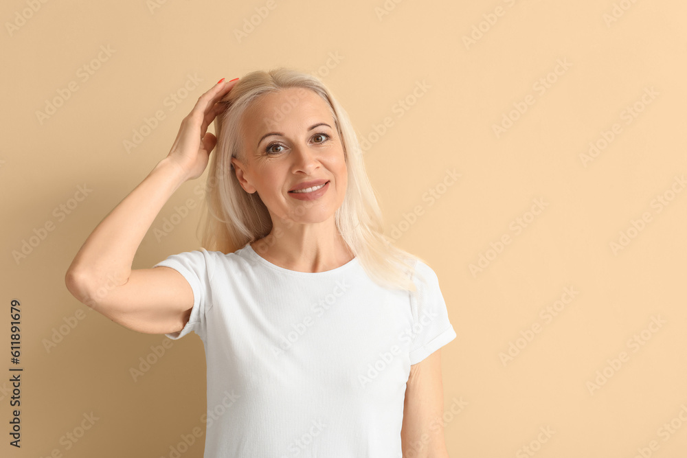 Mature blonde woman on beige background