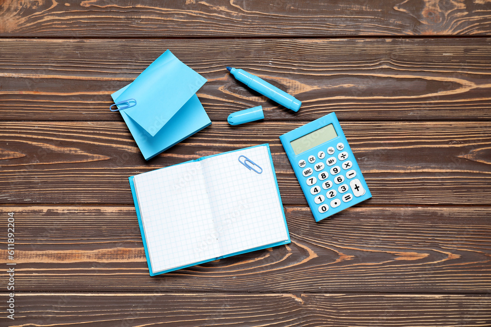 Sticky notes with notebook and calculator on brown wooden background