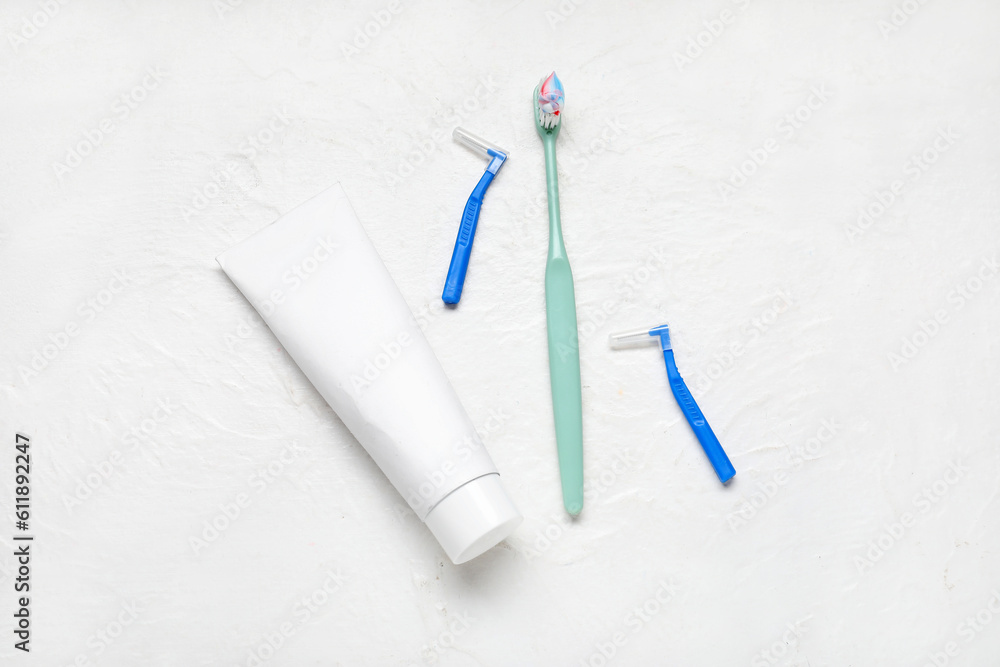 Toothbrush, toothpicks and paste on textured white background