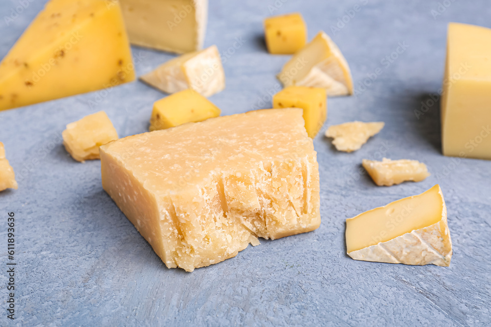 Pieces of tasty cheese on grey background