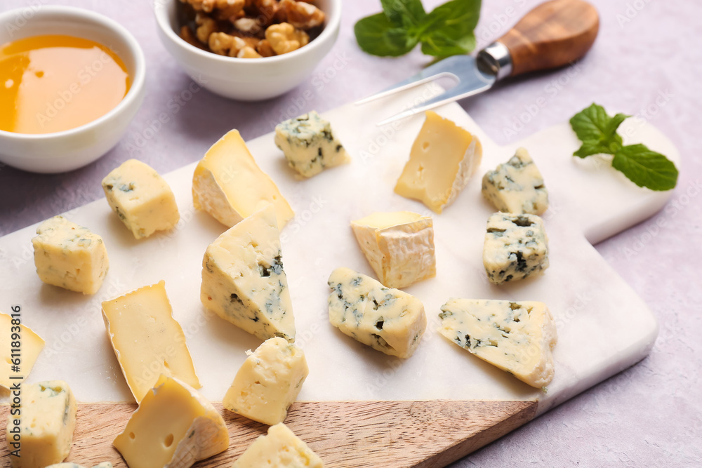 Board with pieces of tasty cheese on light background, closeup