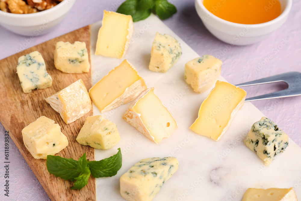 Board with pieces of tasty cheese on light background, closeup