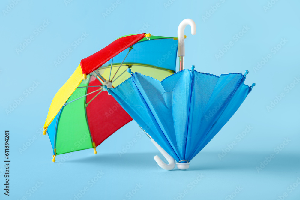 Colorful mini umbrellas on blue background