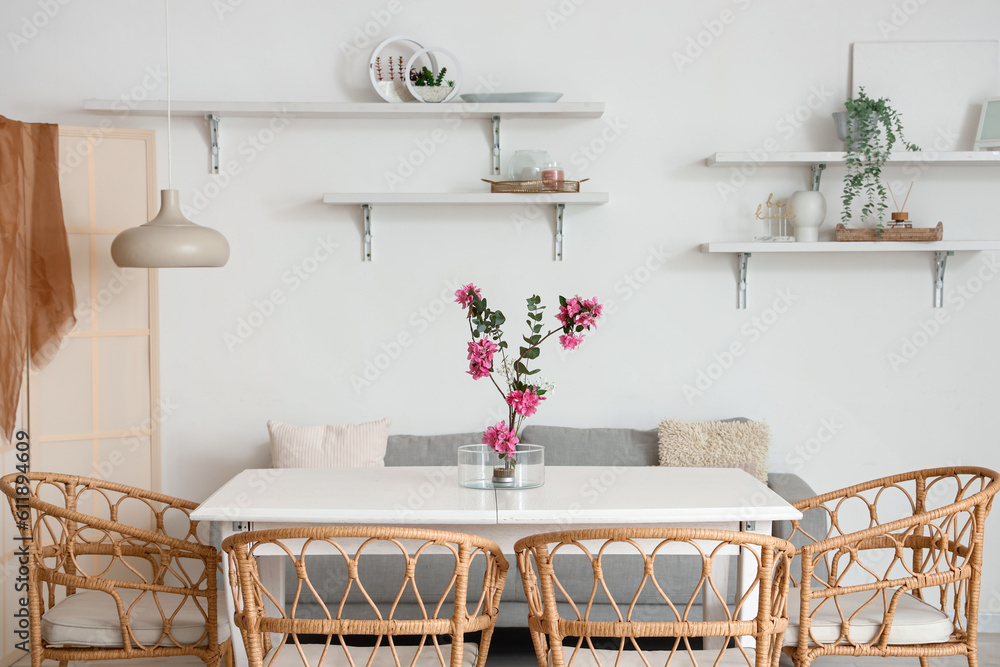 Interior of dining room with ikebana on table and shelves