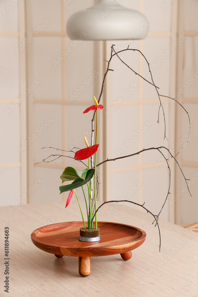 Beautiful ikebana on dining table in room