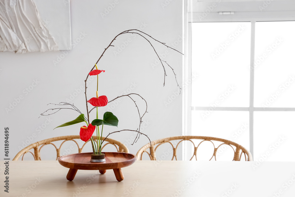 Beautiful ikebana on dining table in room