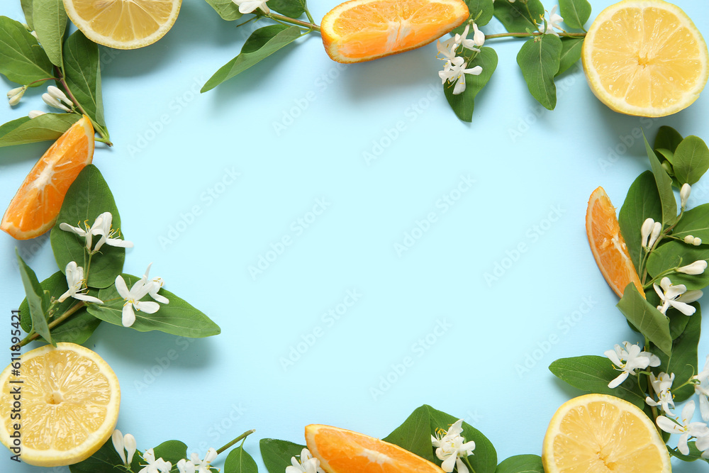 Frame made of lemons with blooming branches on blue background