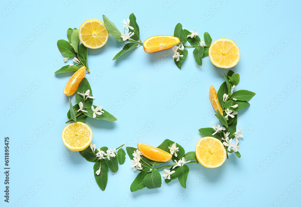 Frame made of lemons with blooming branches on blue background