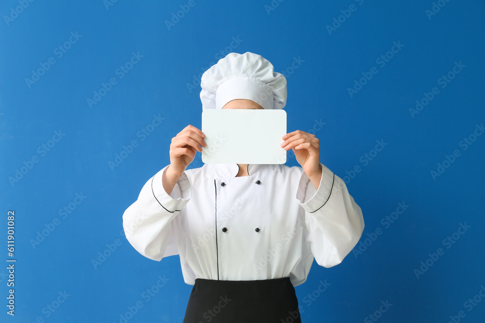 Female chef holding blank card on blue background