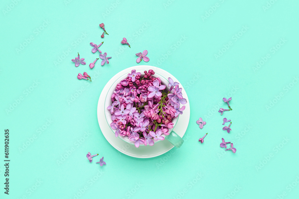 Lilac flowers in cup on turquoise background