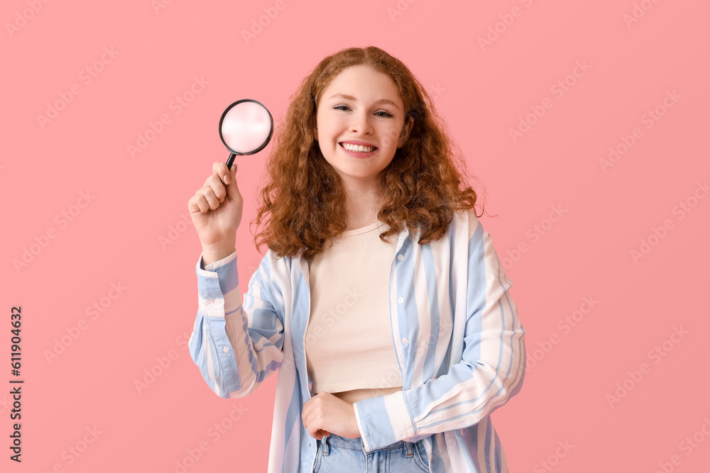 Young woman with magnifier on pink background