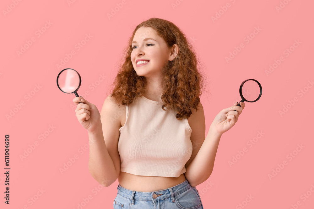 Young woman with magnifiers on pink background