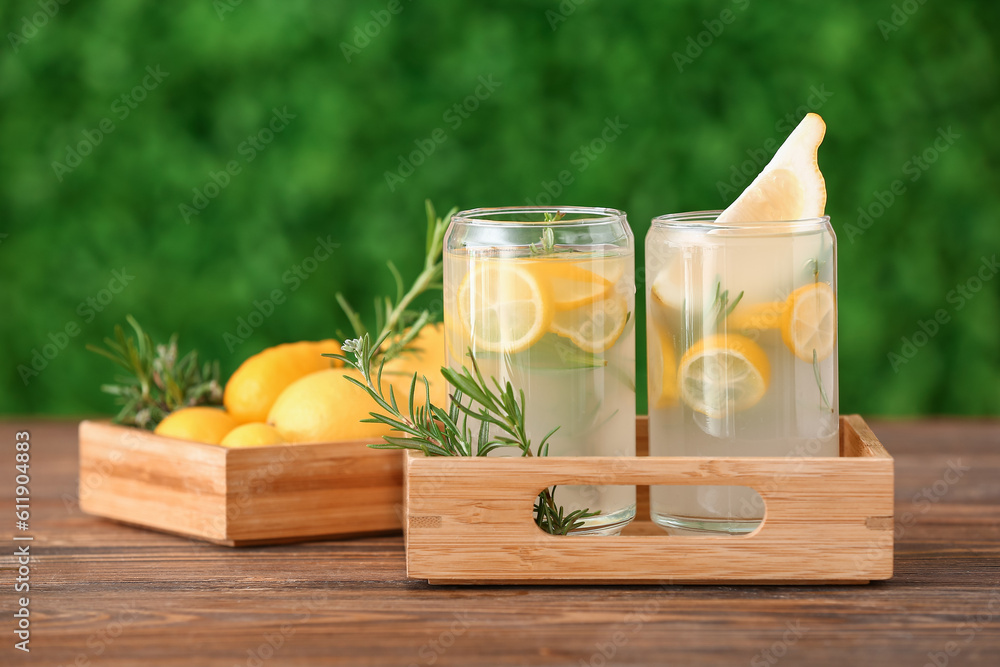 Wooden box of glasses with fresh lemonade on wooden table