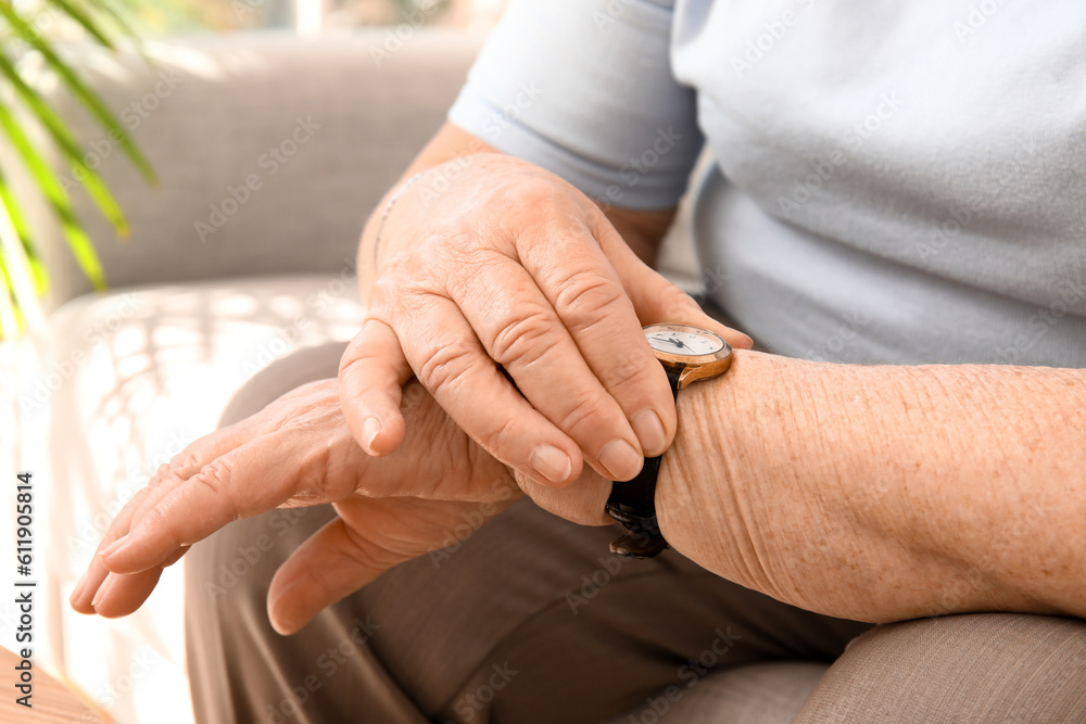 Senior woman with wristwatch at home, closeup