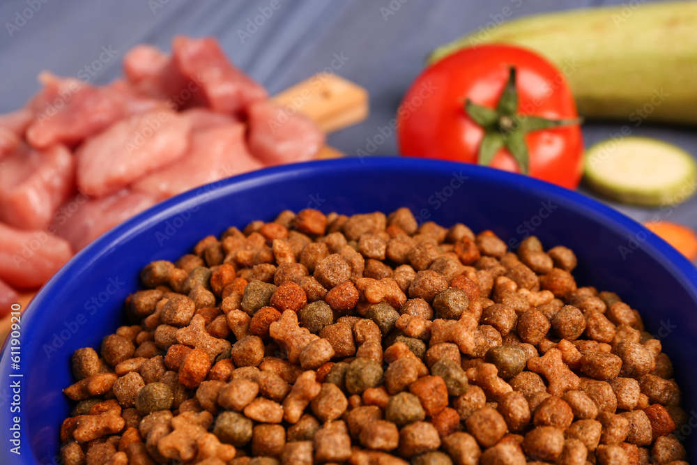 Bowl with dry pet food on table, closeup