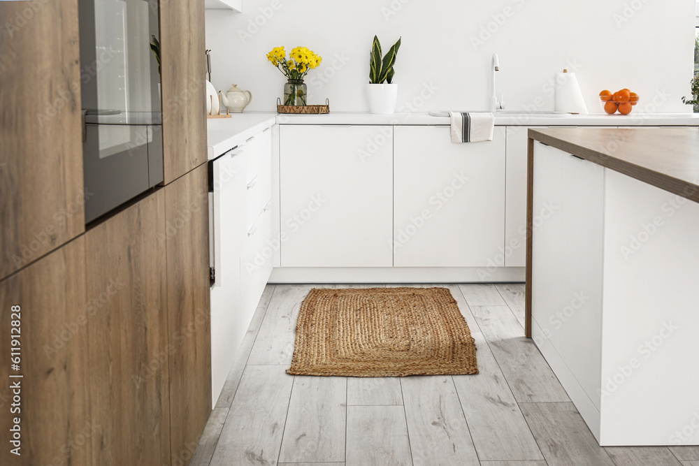 Wicker rug on floor in interior of light kitchen