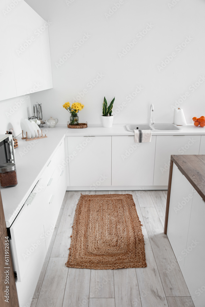 Wicker rug on floor in interior of light kitchen