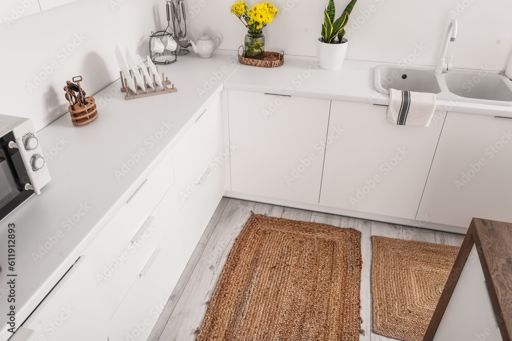 Wicker rug on floor in interior of light kitchen