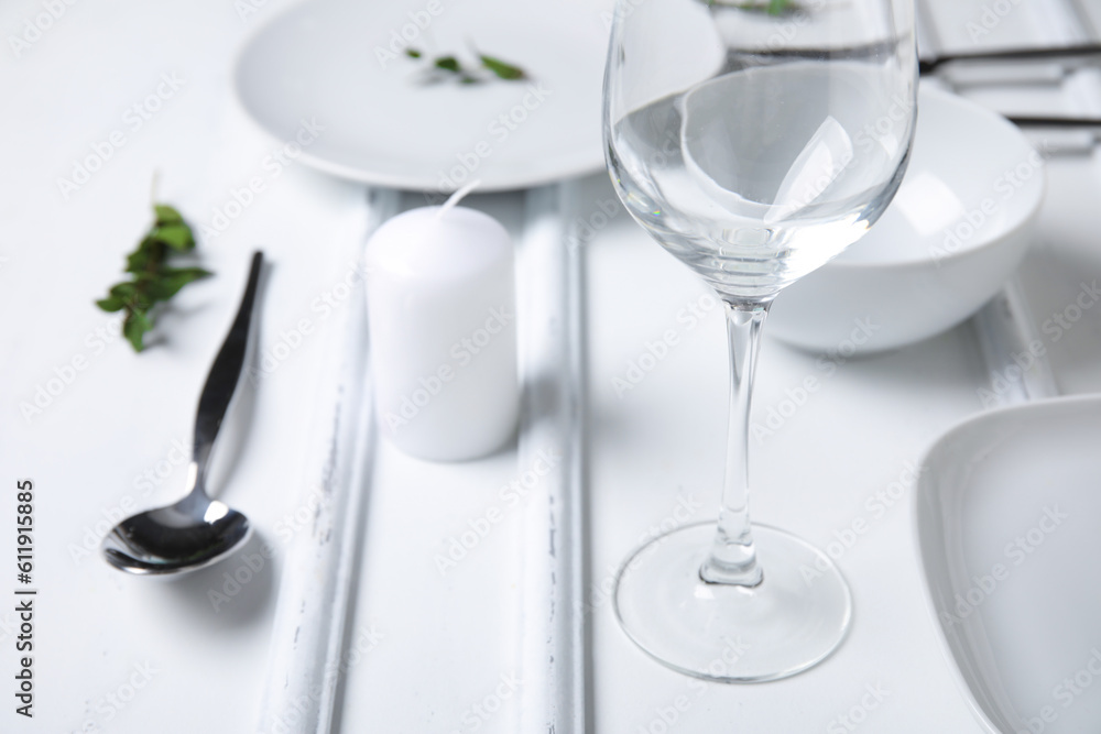 Stylish table setting and candle on white wooden background