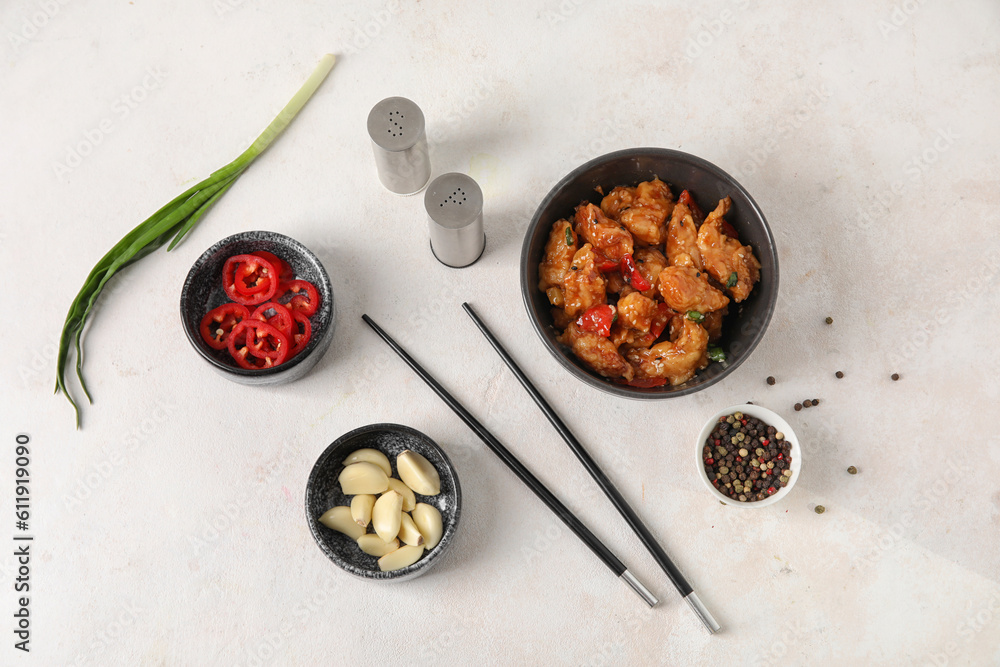 Tasty sweet and sour chicken in bowl with spices on white background