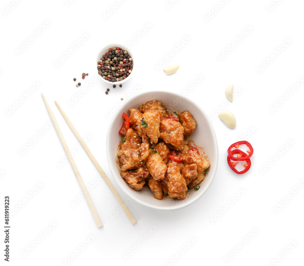 Tasty sweet and sour chicken in bowl with spices on white background