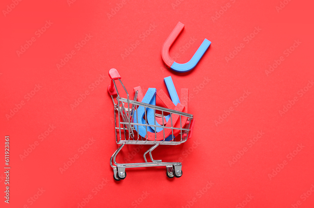 Mini trolley with magnets on red background