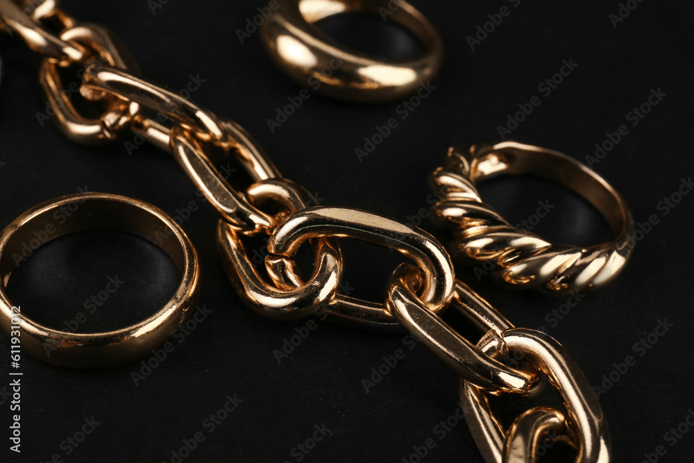 Beautiful chain bracelet and rings on black background