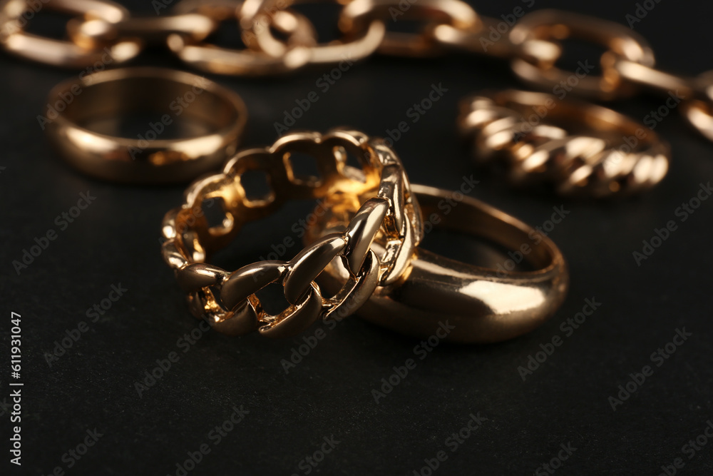 Beautiful chain bracelet and rings on black background