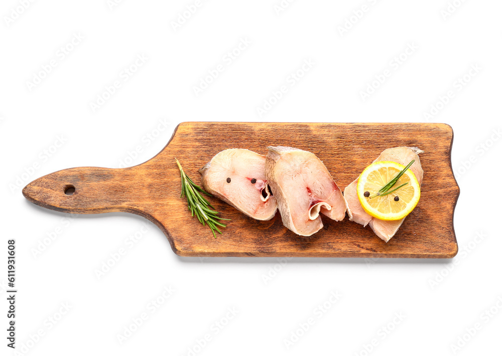 Wooden board with pieces of raw codfish on white background