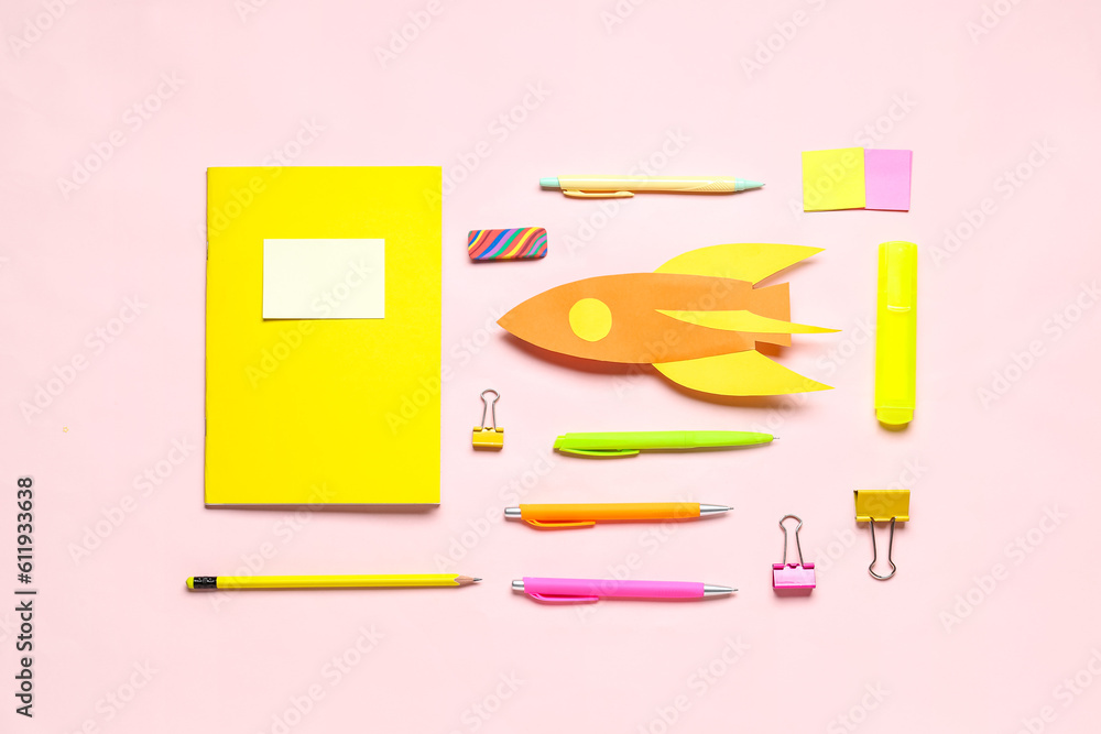 Paper rocket with different stationery on pink background