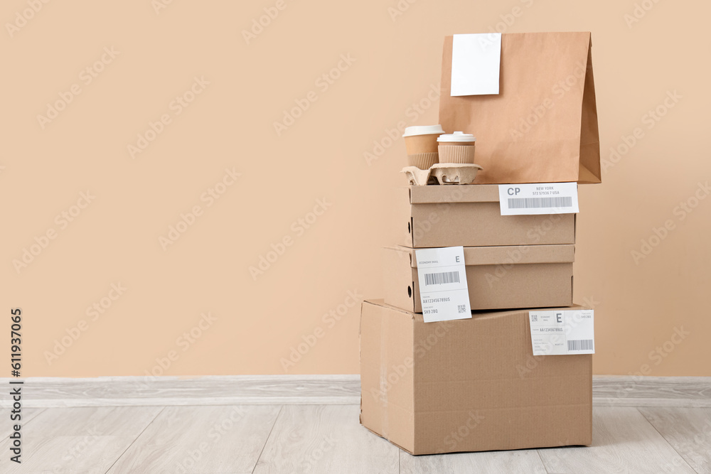 Parcels and containers with food on floor near beige wall