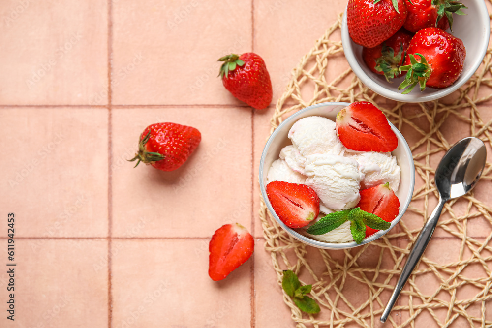 Bowl of vanilla ice cream with strawberries, mint and spoon on beige tile table