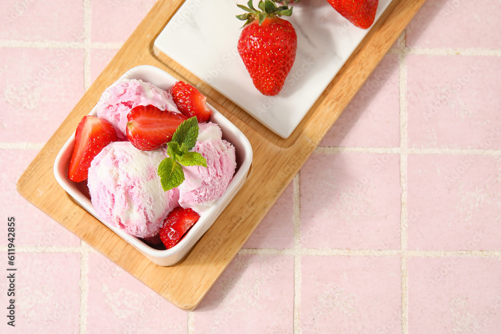 Square bowl of strawberry ice cream with mint, berries and board on pink tile table