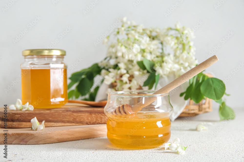 Composition with sweet honey and acacia flowers on light background, closeup