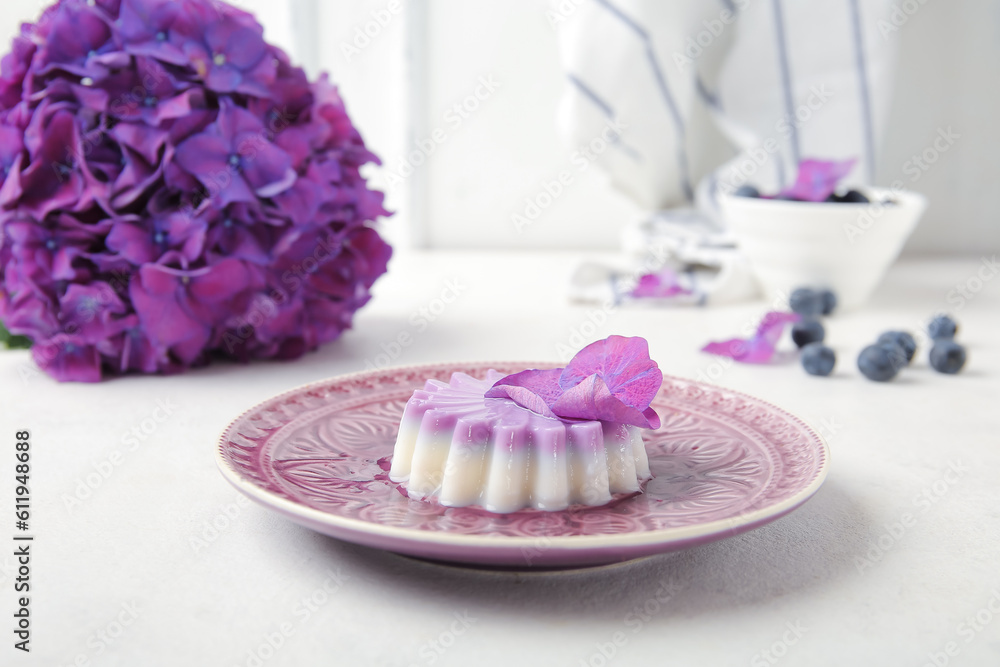 Plate of panna cotta with beautiful hydrangea flowers and blueberry on white table