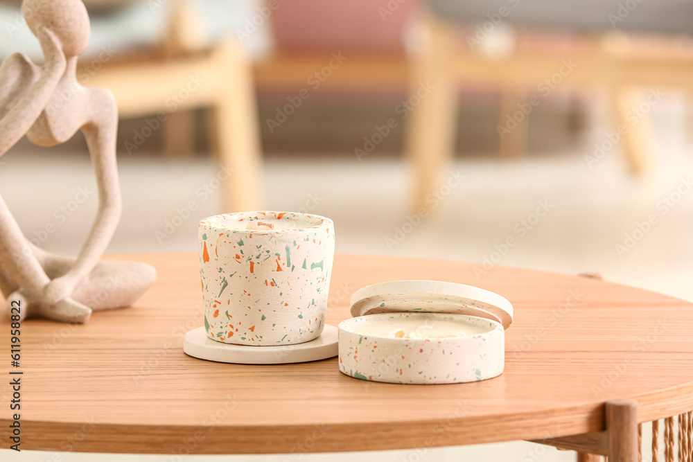 Holders with candles and decor on table in room, closeup