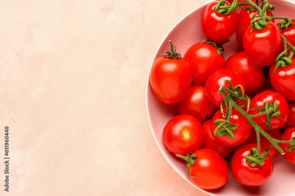 Bowl with fresh cherry tomatoes on pink background